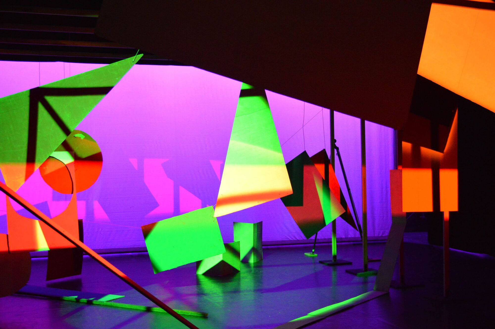 Verschiedene Objekte auf der Bühne. Beleuchtung in verschiedenen Farben: rot, orange, lila, blau, grün und gelb.
