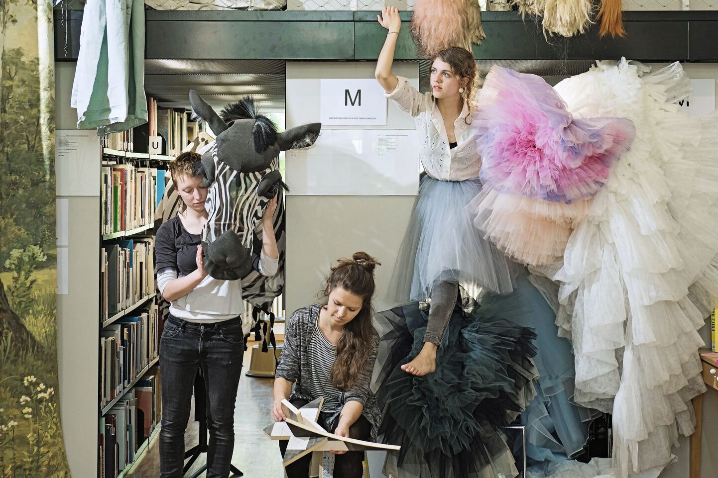 Fünf Studentinnen mit Kostümen in der Hochschulbibliothek. Fünf Studentinnen mit Kostümen in der Hochschulbibliothek.