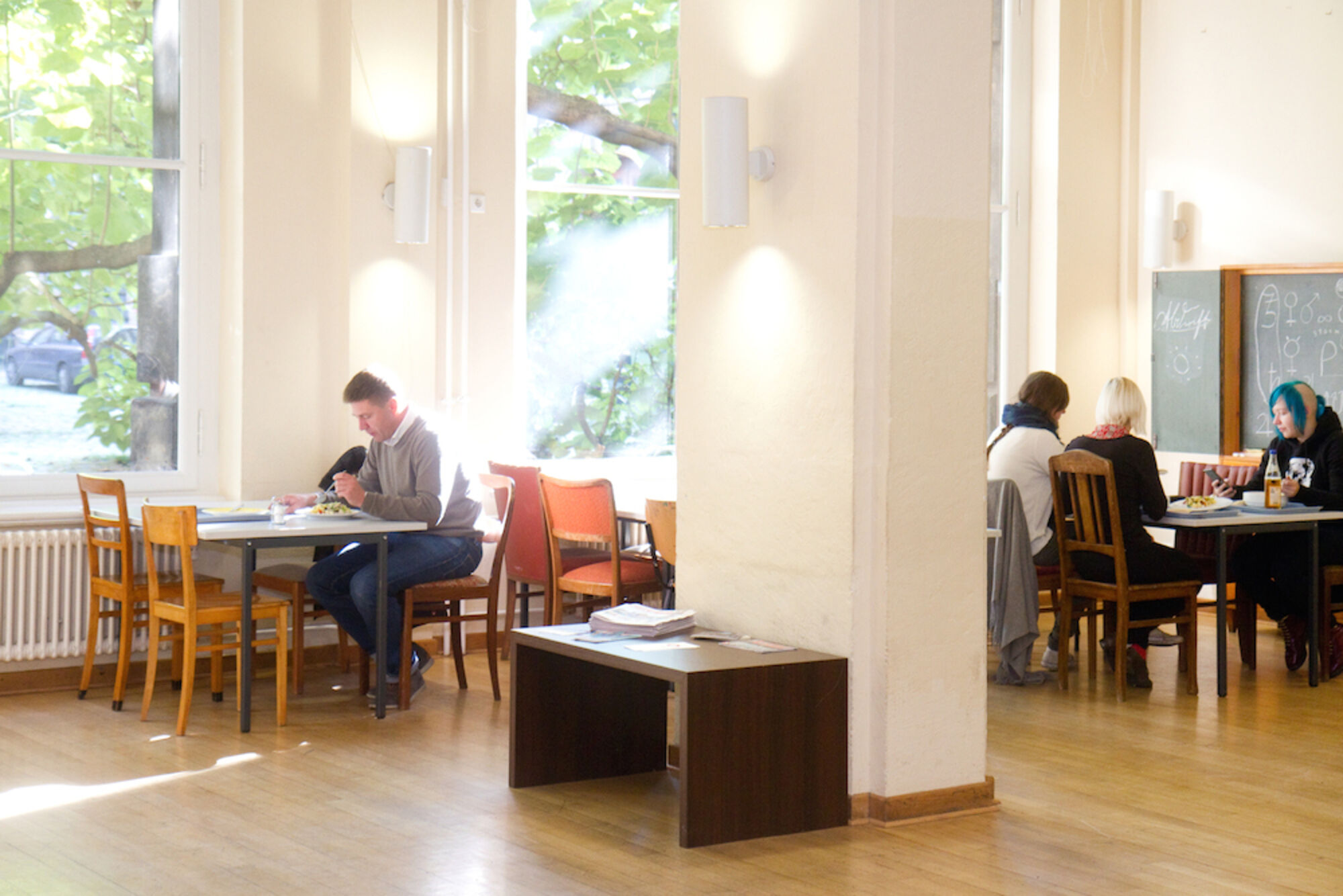 Mensa der Hochschule. Menschen essen am Tisch.