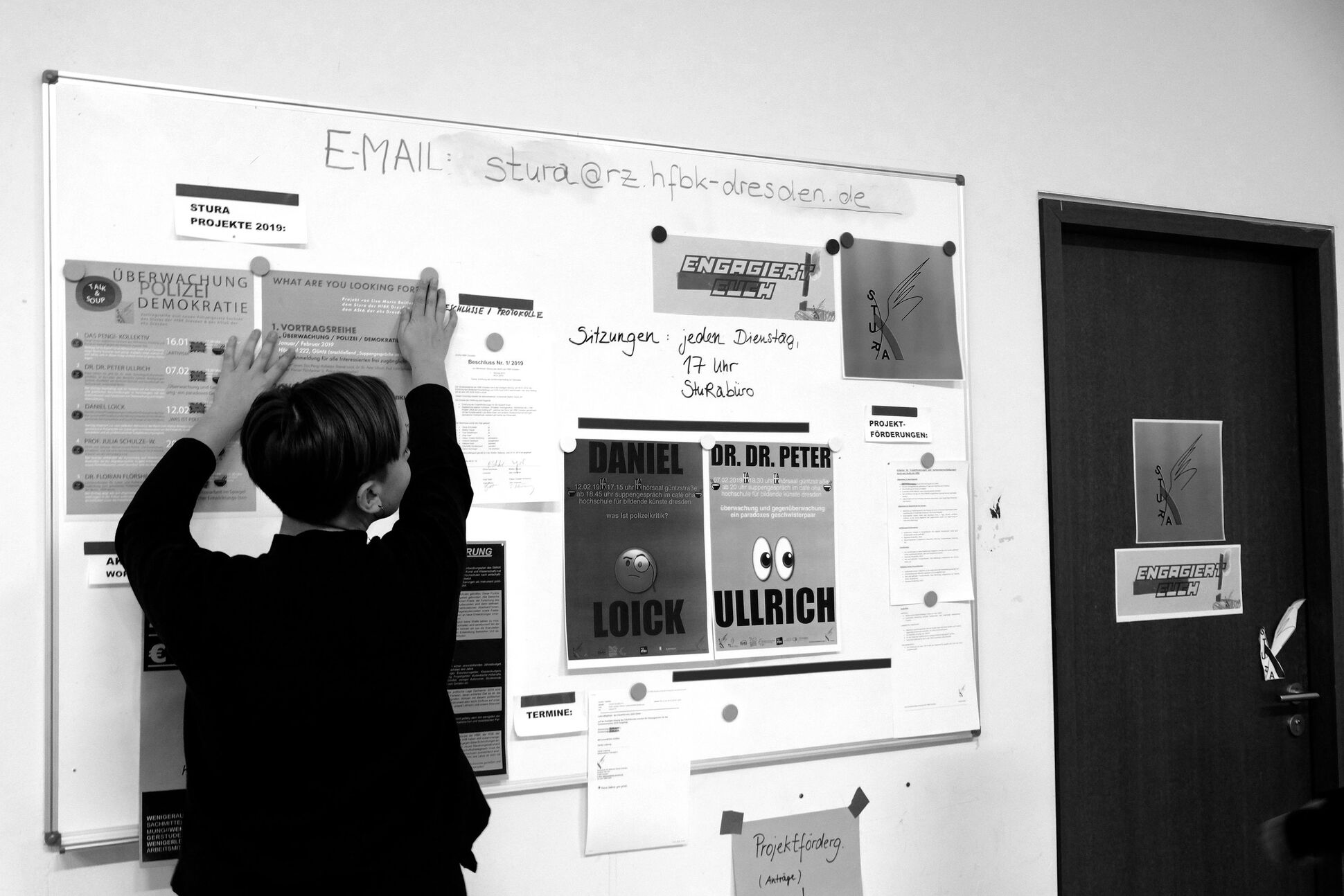 Eine Mitgliederin des Studentenrats hängt die Plakate an. Eine Mitgliederin des Studentenrats hängt die Plakate an.