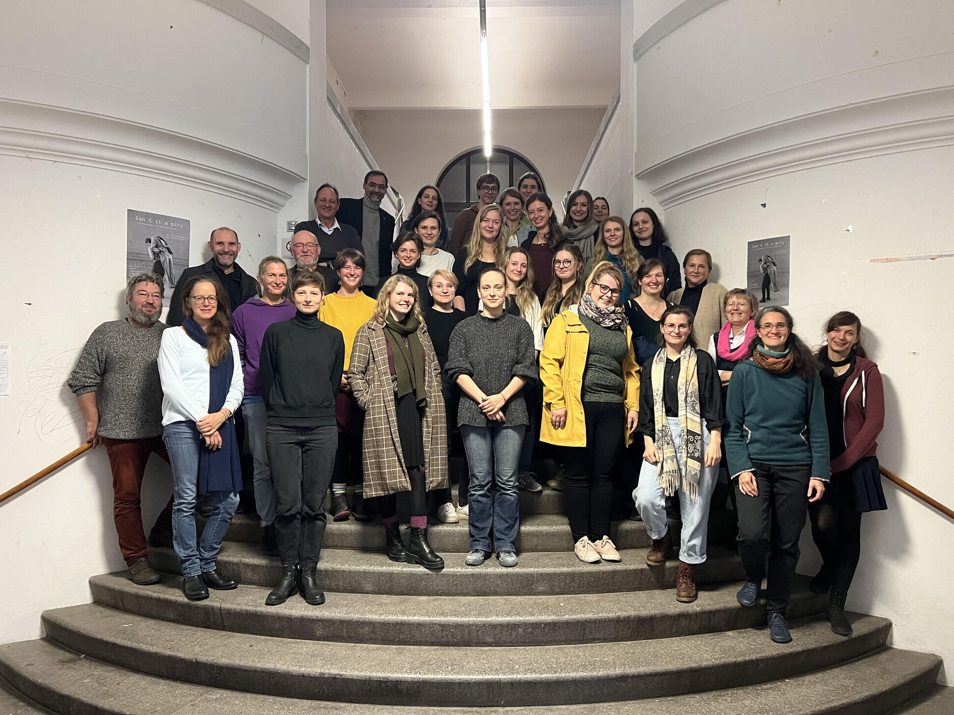 Gruppenfoto, weitwinkling aufgenommen, lächelnde Menschen stehen auf einer Treppe Gruppenfoto, weitwinkling aufgenommen, lächelnde Menschen stehen auf einer Treppe