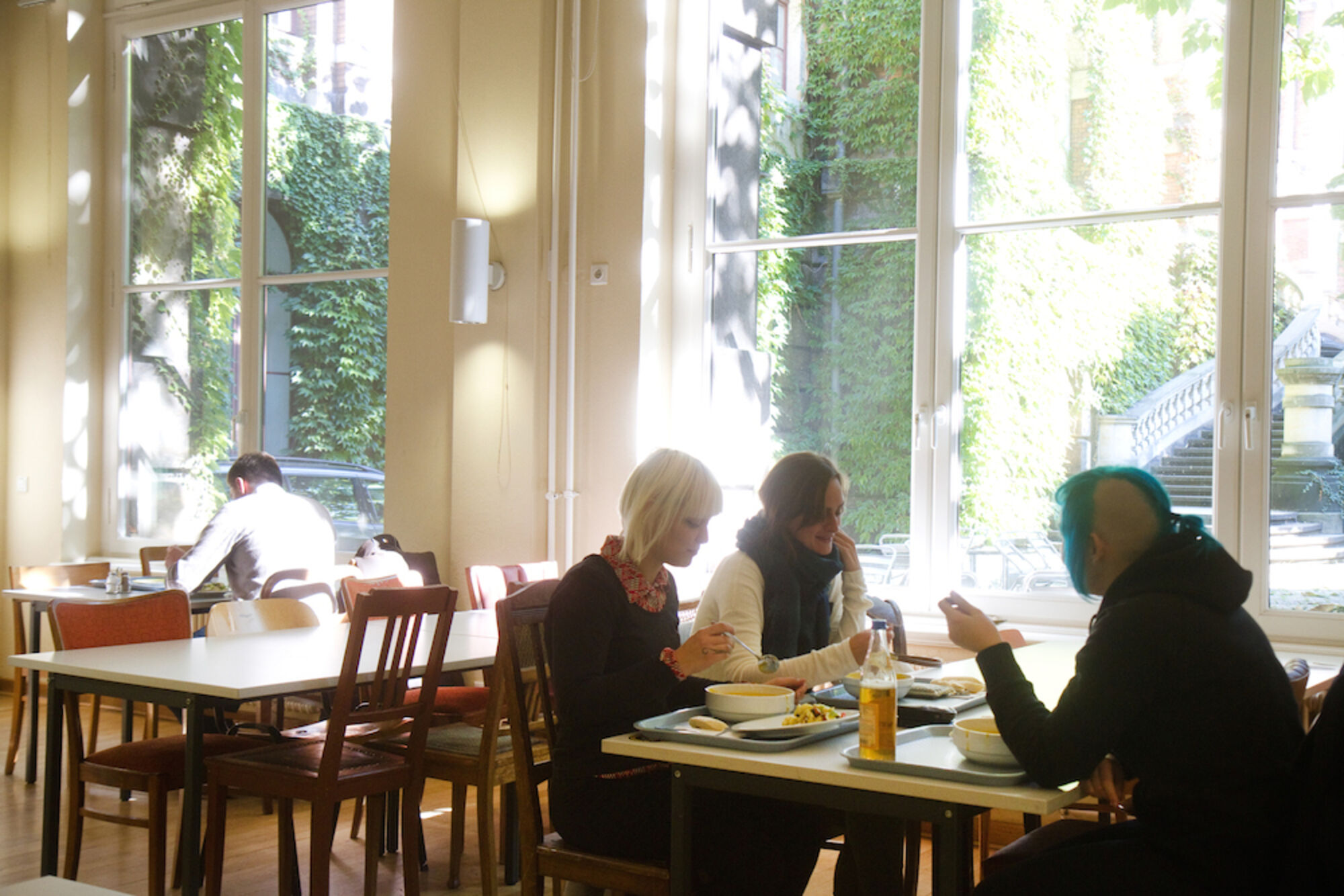 Mensa der Hochschule. Menschen essen am Tisch.