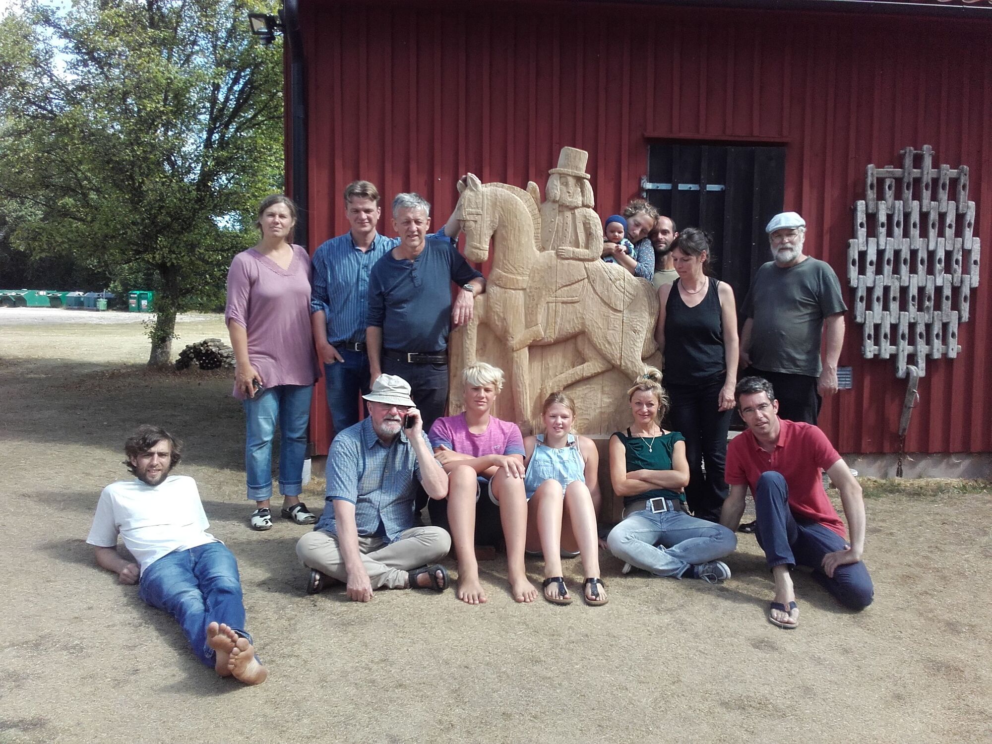 Gruppenfoto von Menschen mit einer Skulptur von einem Reiter und Pferd.
