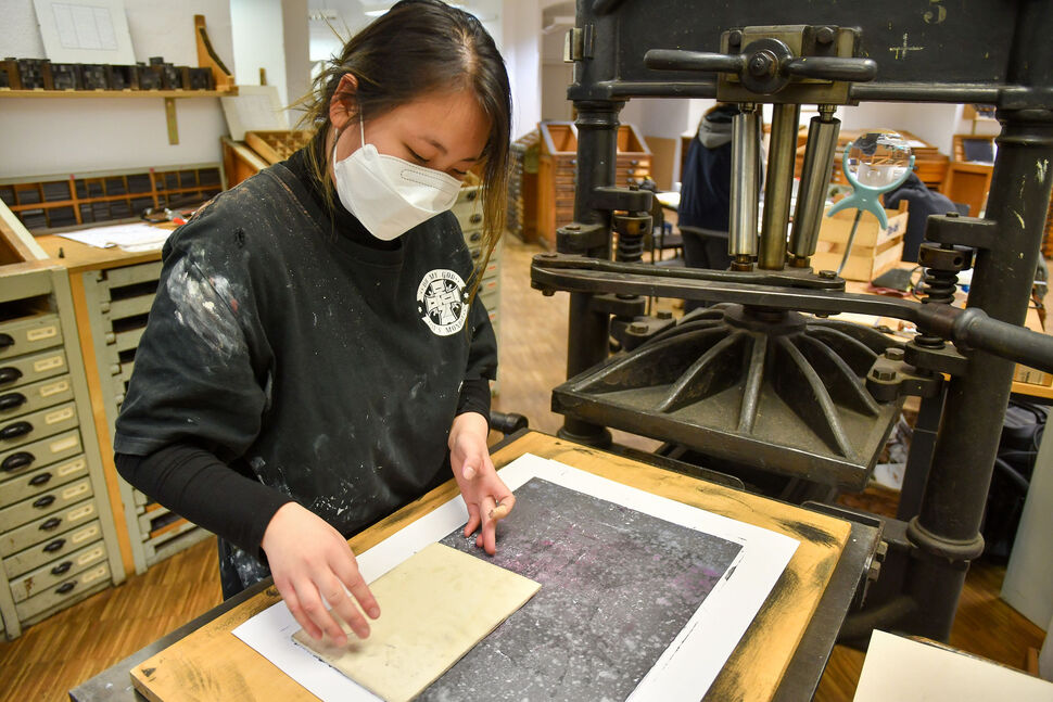 Foto Studentin an Druckpresse