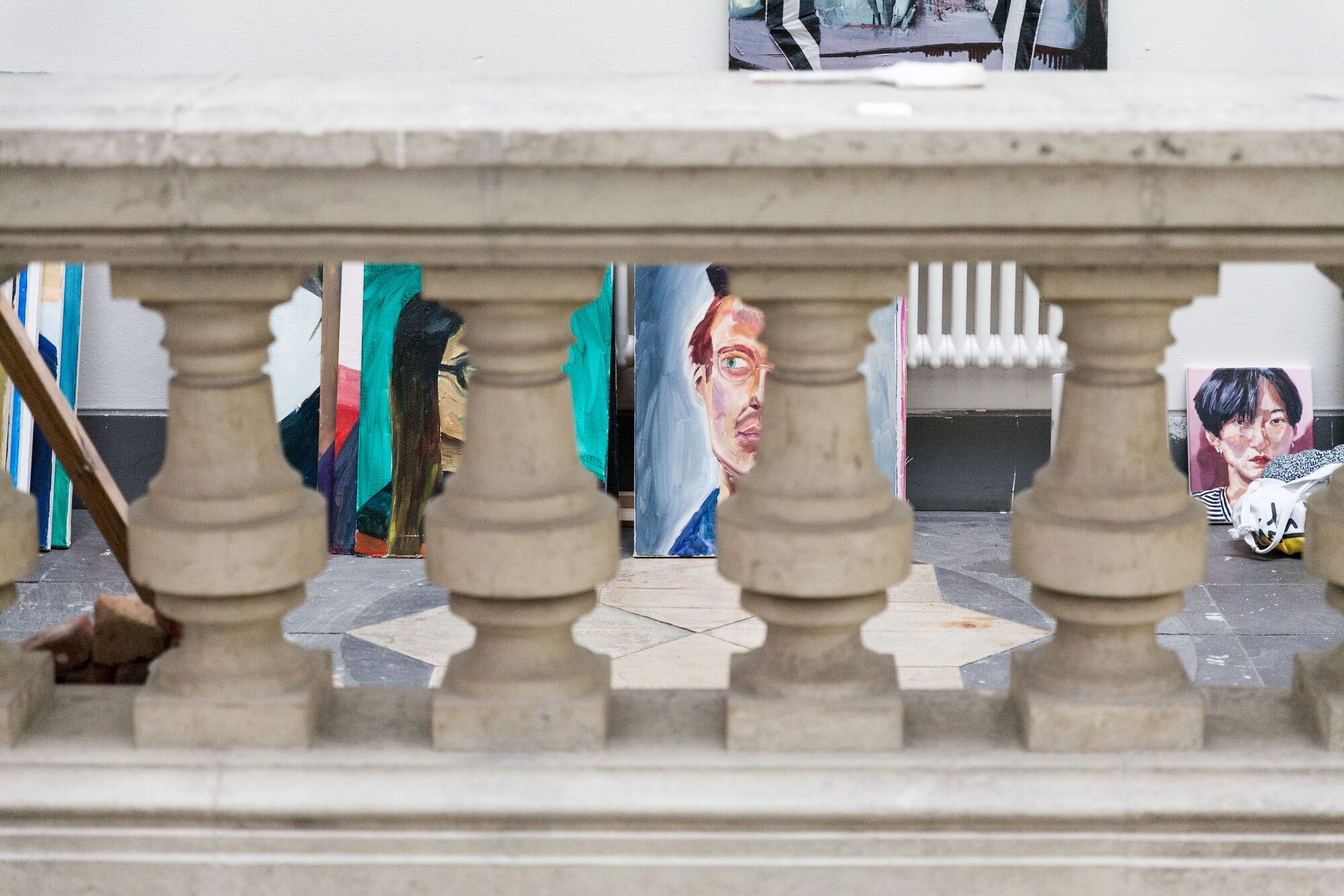 Gemälde in der Flur der Hochschule. Im Vordergrund Säulen aus Stein.