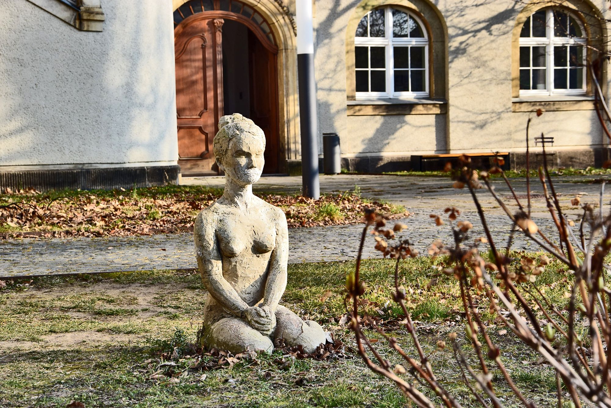 Innenhof der Gebäudekomplex der Hochschule an der Güntzstraße. Gartenskulptur von einer Frau.