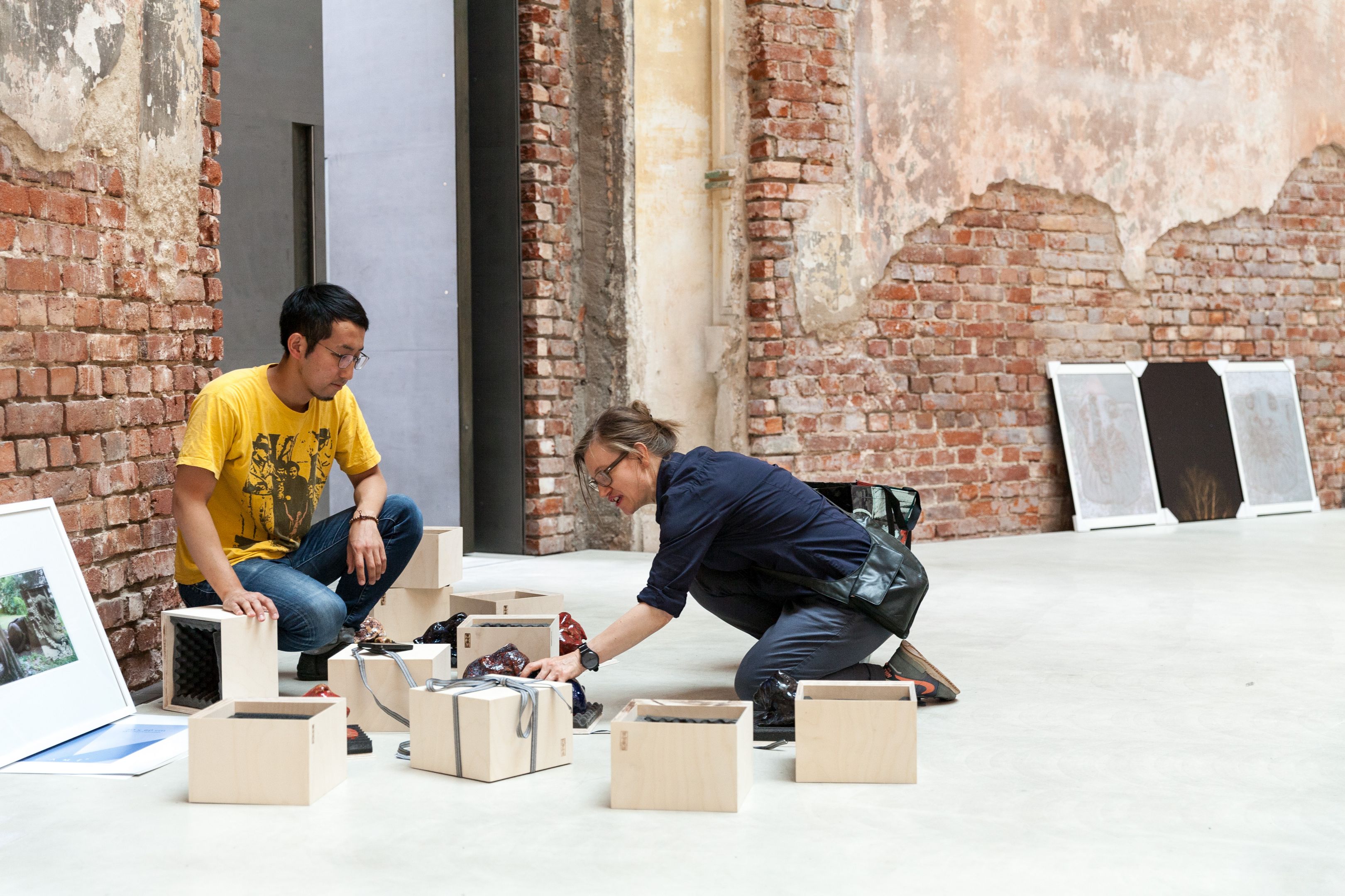 Aufbau der Jahresausstellung. Eine Frau und ein Mann beim Gespräch.
