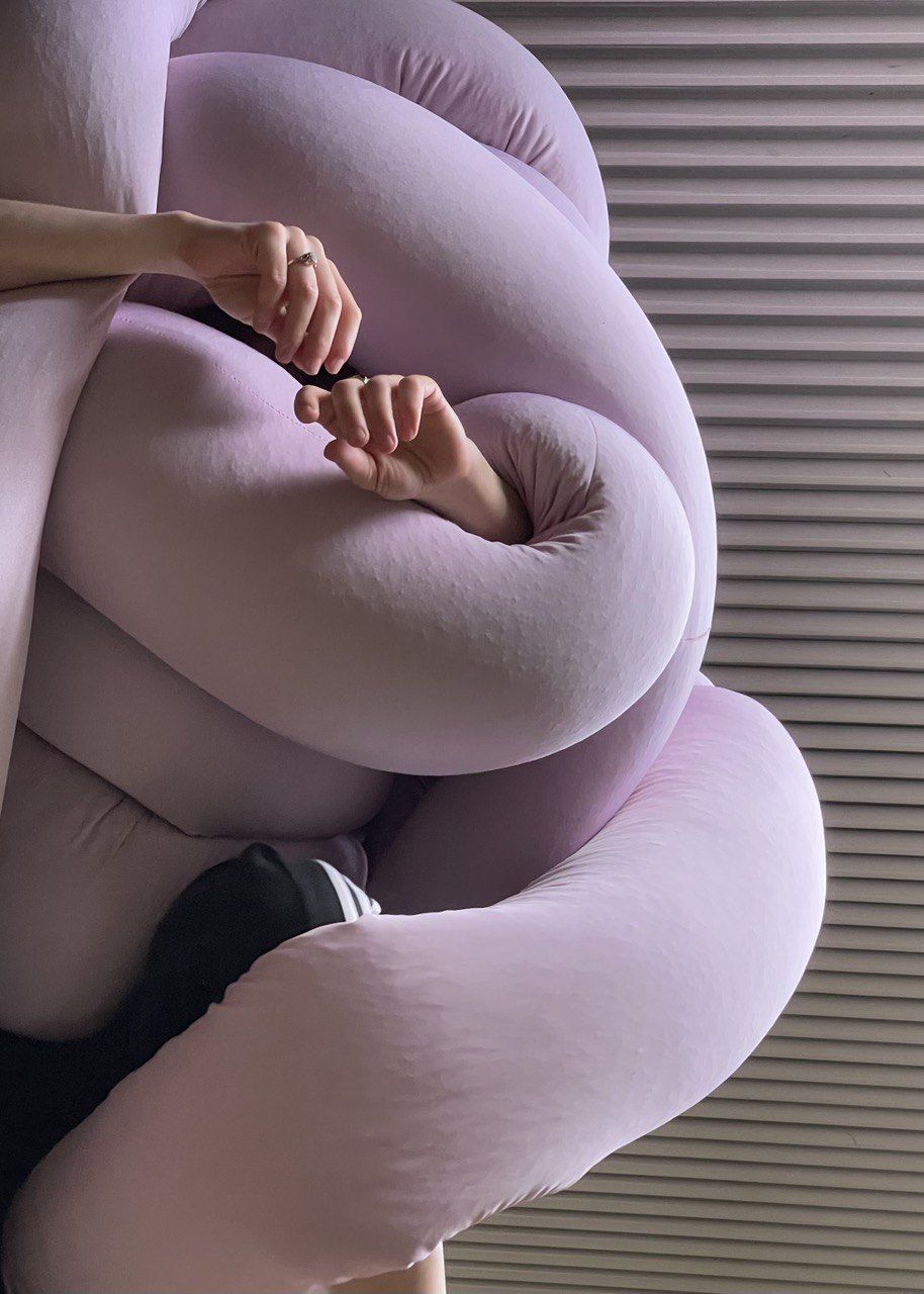 Hände hängen entspannt aus einer rosigen Stoffwurst. Hände hängen entspannt aus einer rosigen Stoffwurst.