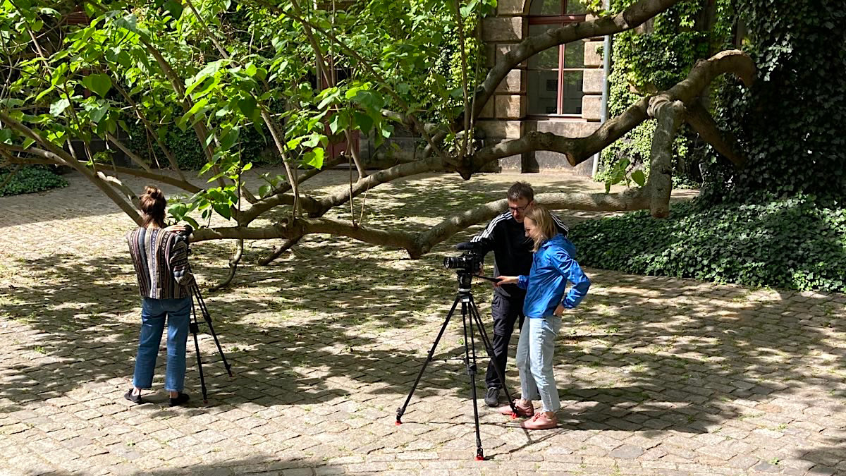 Personen mit einer Kamera im Hof der HfBK Personen mit einer Kamera im Hof der HfBK