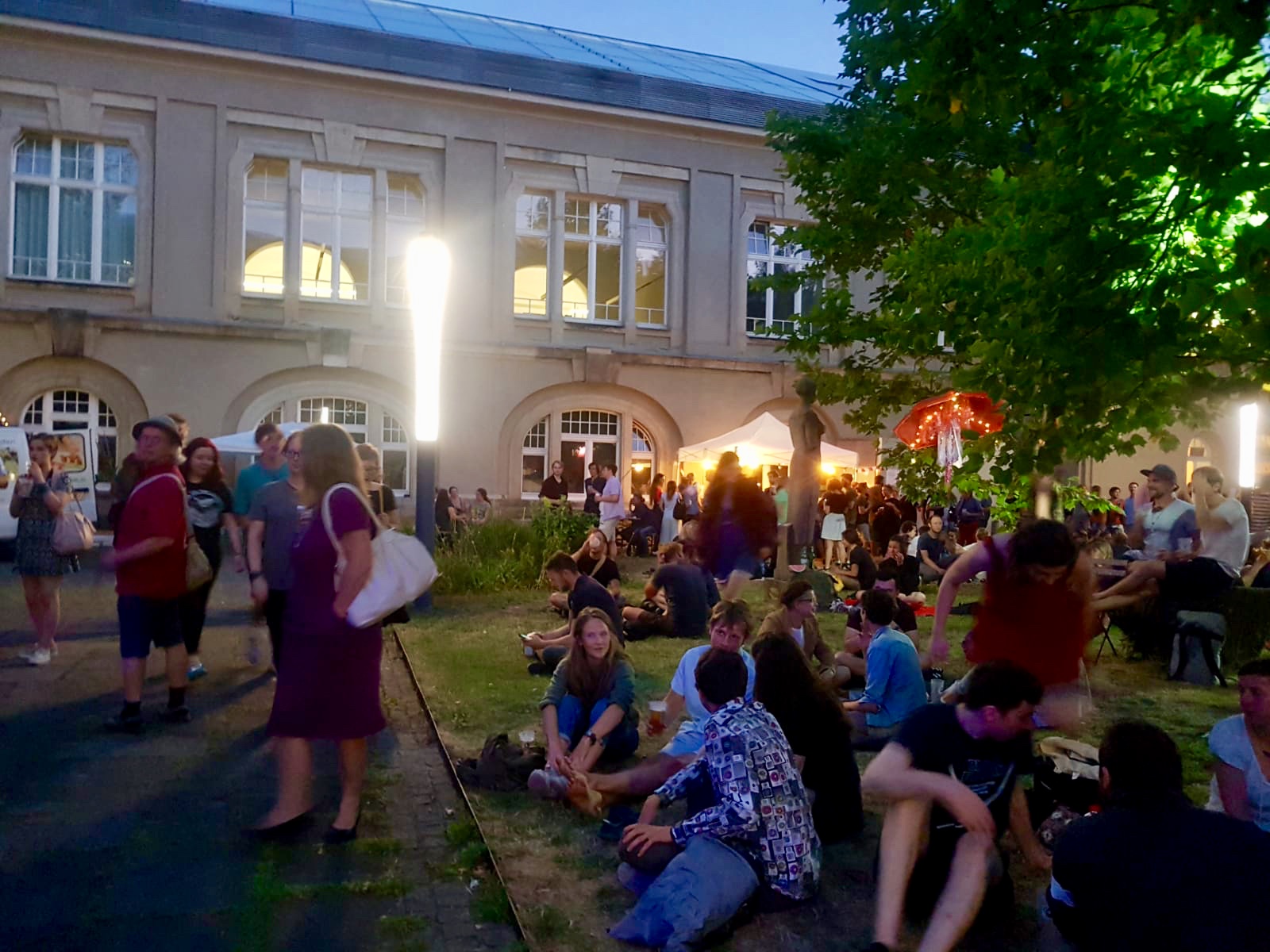Innenhof der Hochschule an der Güntzstraße in der Nacht. Menschen unterhalten sich während des Sommerfestes.