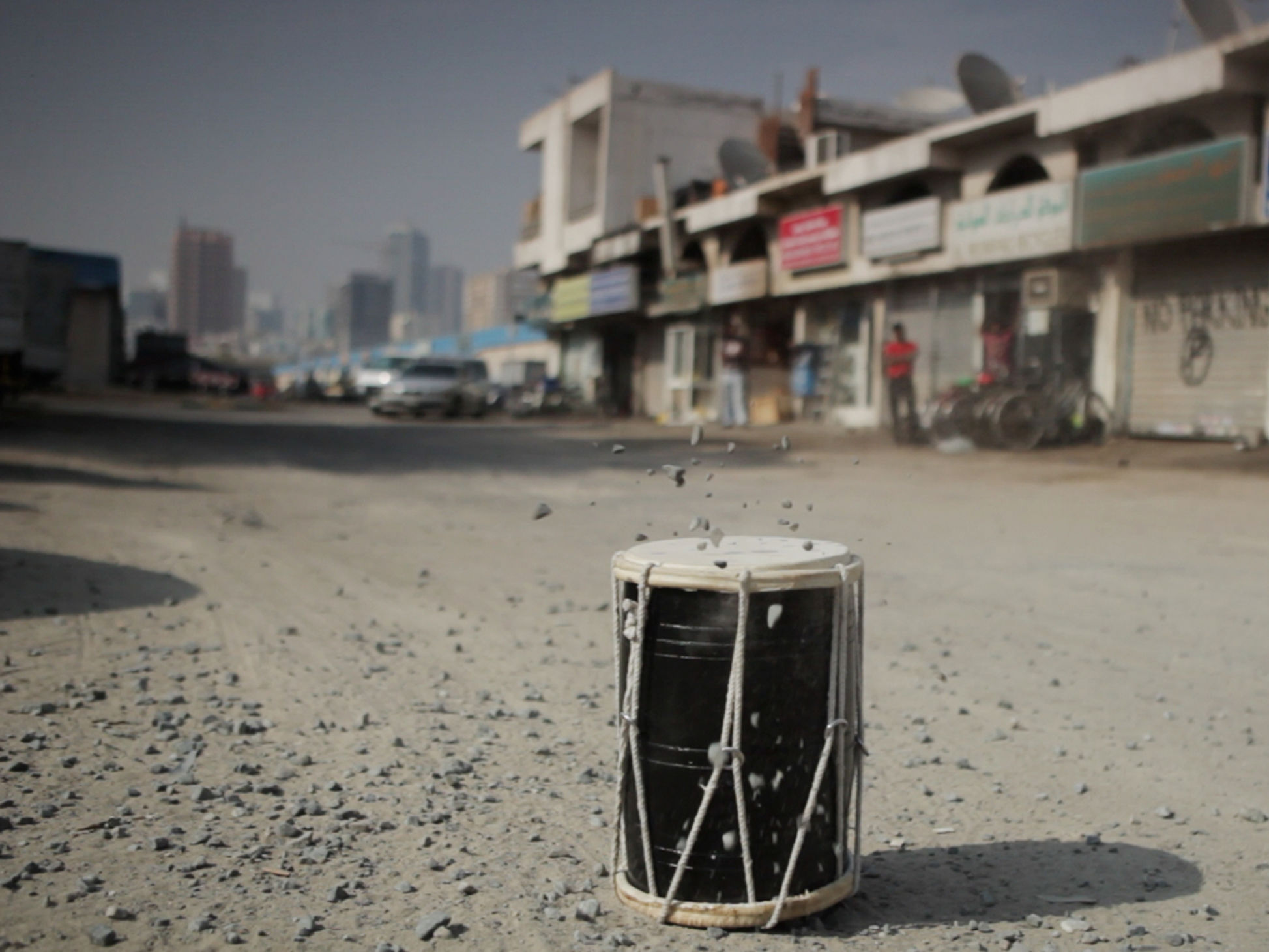Kunstwerk von Nevin Aladag. Schwarze Trommel und kleine Steine im Vordergrund.
