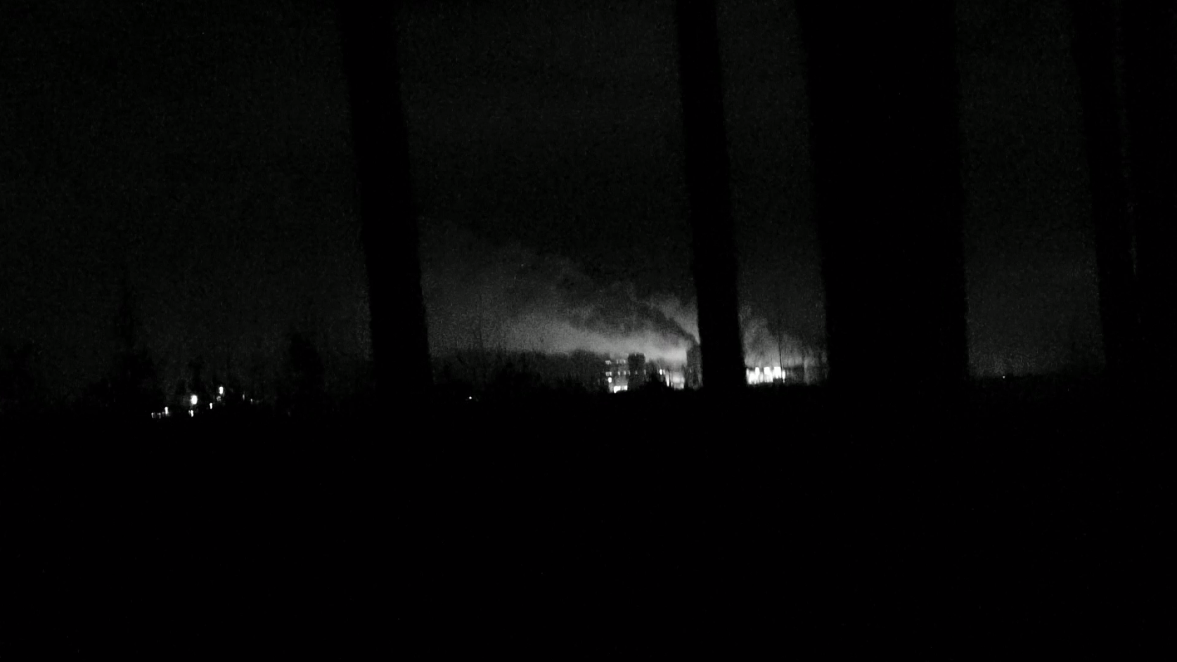 Filmausschnitt - verschwommen - Häusersilhouetten vor Bäumen bei Nacht Filmausschnitt - verschwommen - Häusersilhouetten vor Bäumen bei Nacht