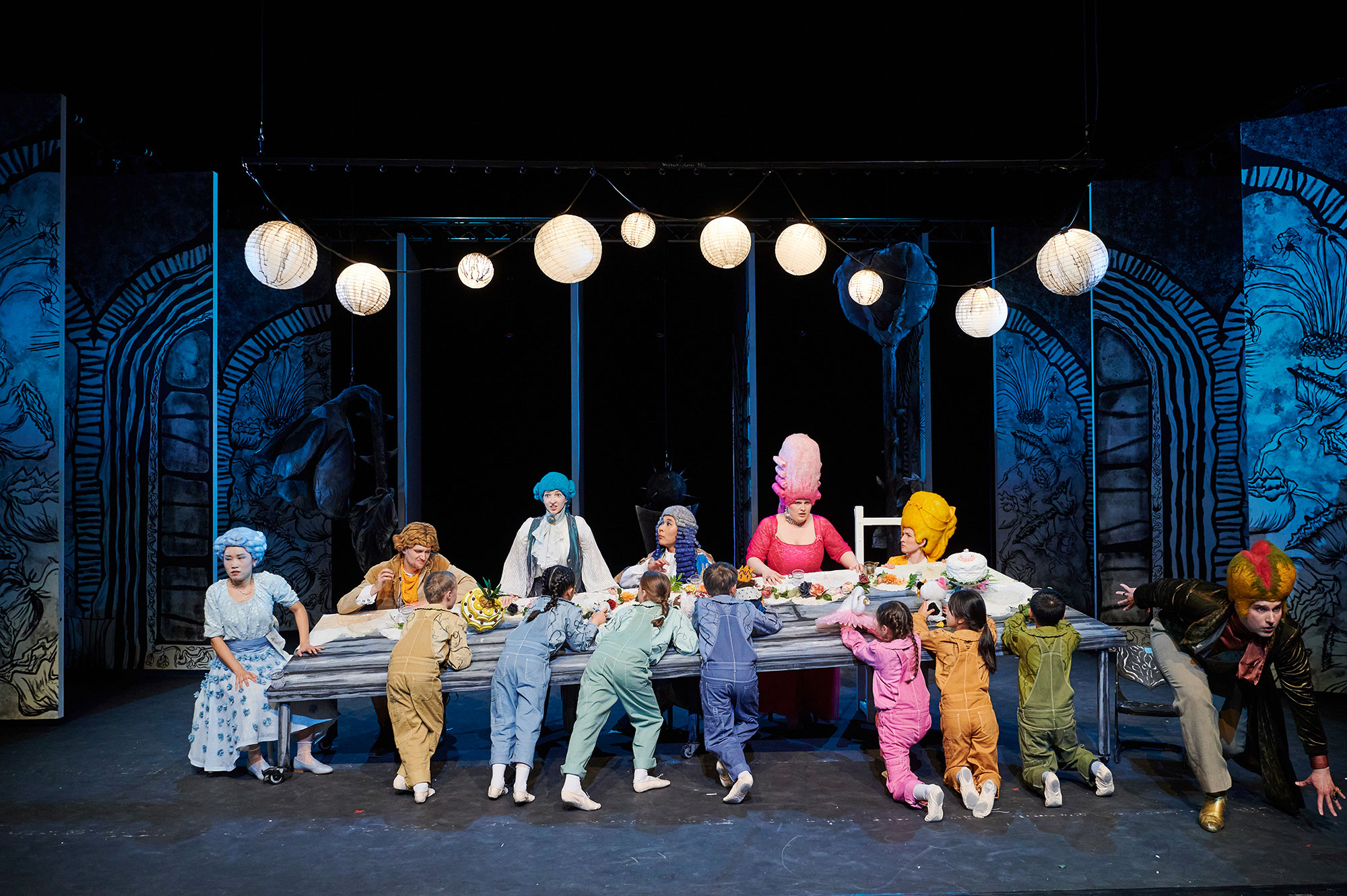 Szenenbild "La Finta", die Sänger*innen sind auf der Bühne an einer langen Tafel versammelt