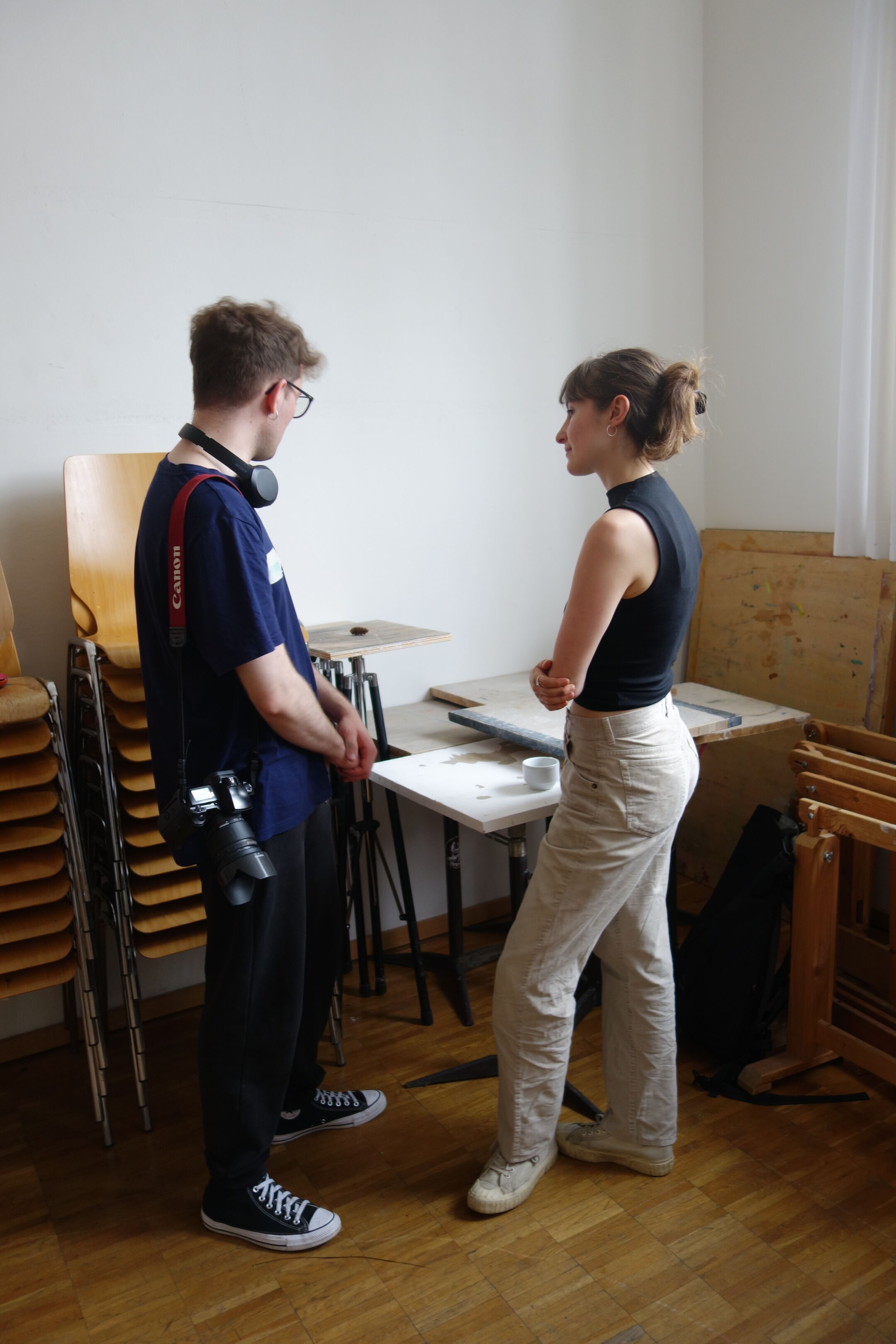 Zwei Personen mit langen Haaren stehen an einem Tisch.