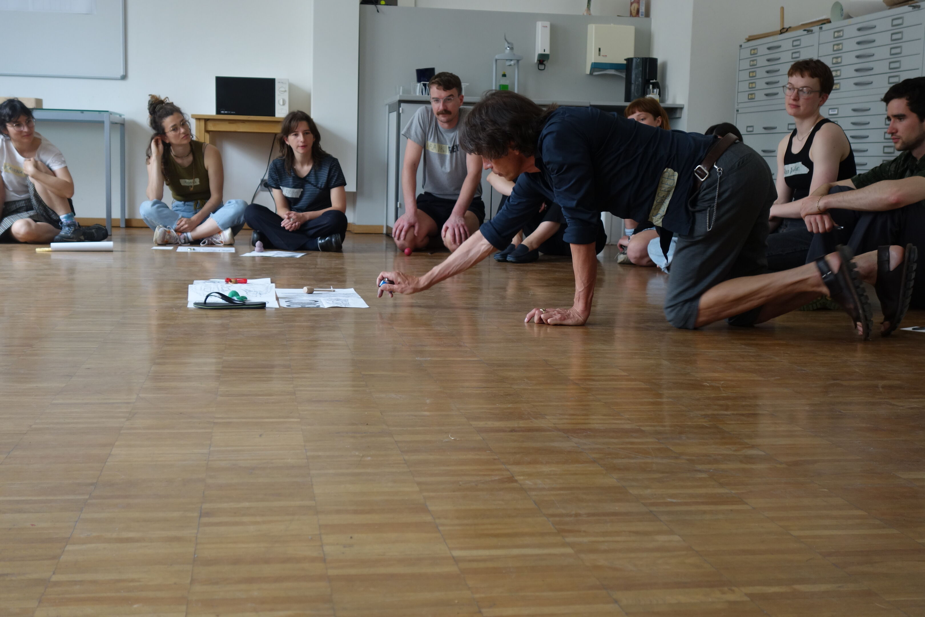 Person auf Knien streckt sich nach einem Gegenstand, der auf dem Boden liegt. Froschperspektive.