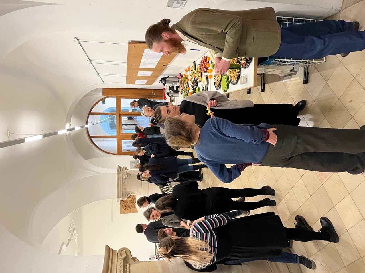 Teilnehmer*innen der Tagung im Gang vor dem Labortheater, im Hintergrunde in Buffet