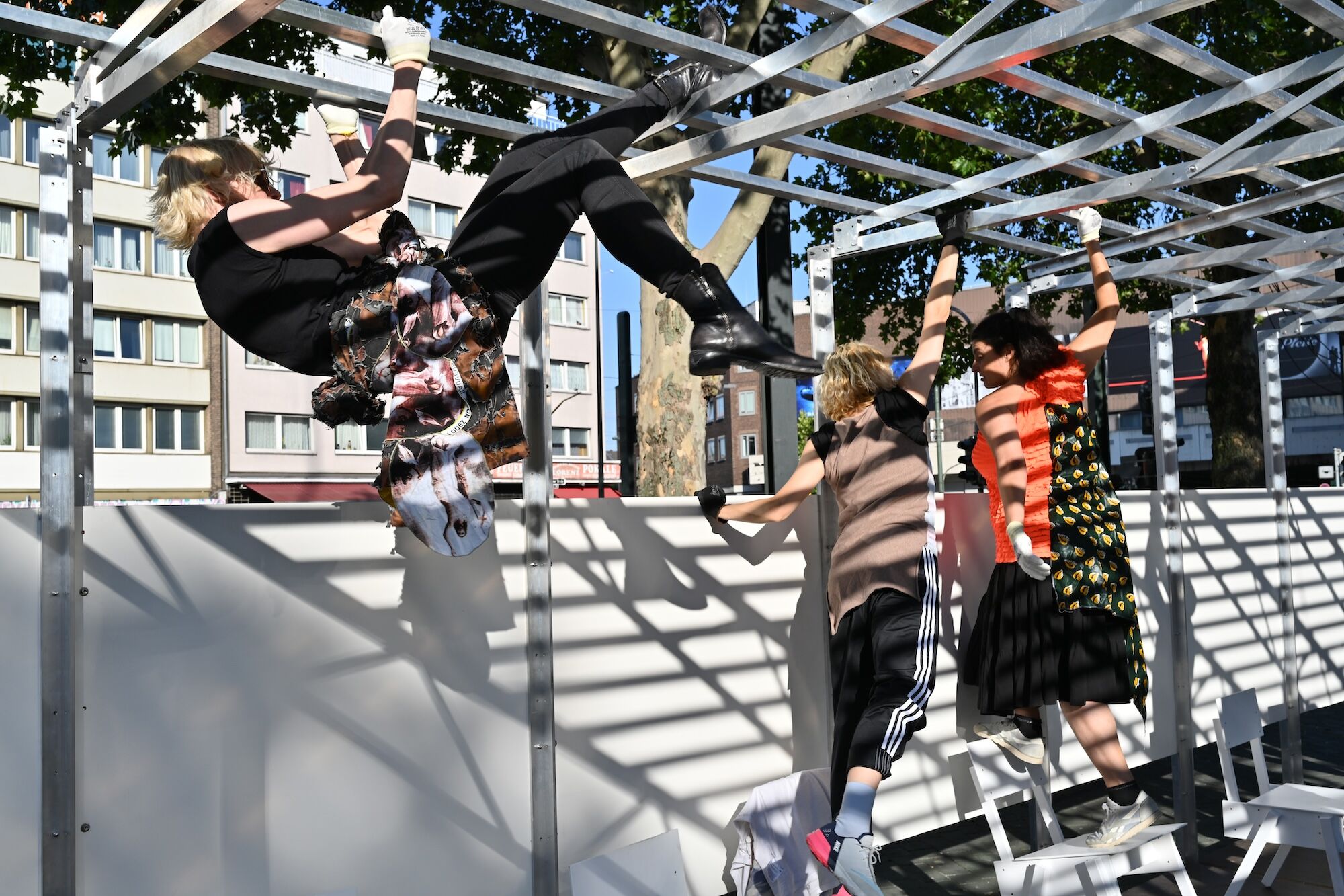 Personen klettern an einem sonnigen Tag in einem Metallgerüst